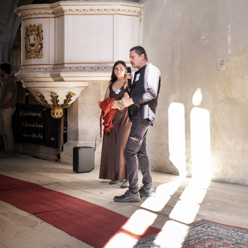 Der Restaurator Loránd Kiss und seine Frau Melinda Janka Kiss stellen die freigelegte Wandmalerei des „Jüngsten Gerichts“ in der evangelischen Kirche von Reichesdorf vor.